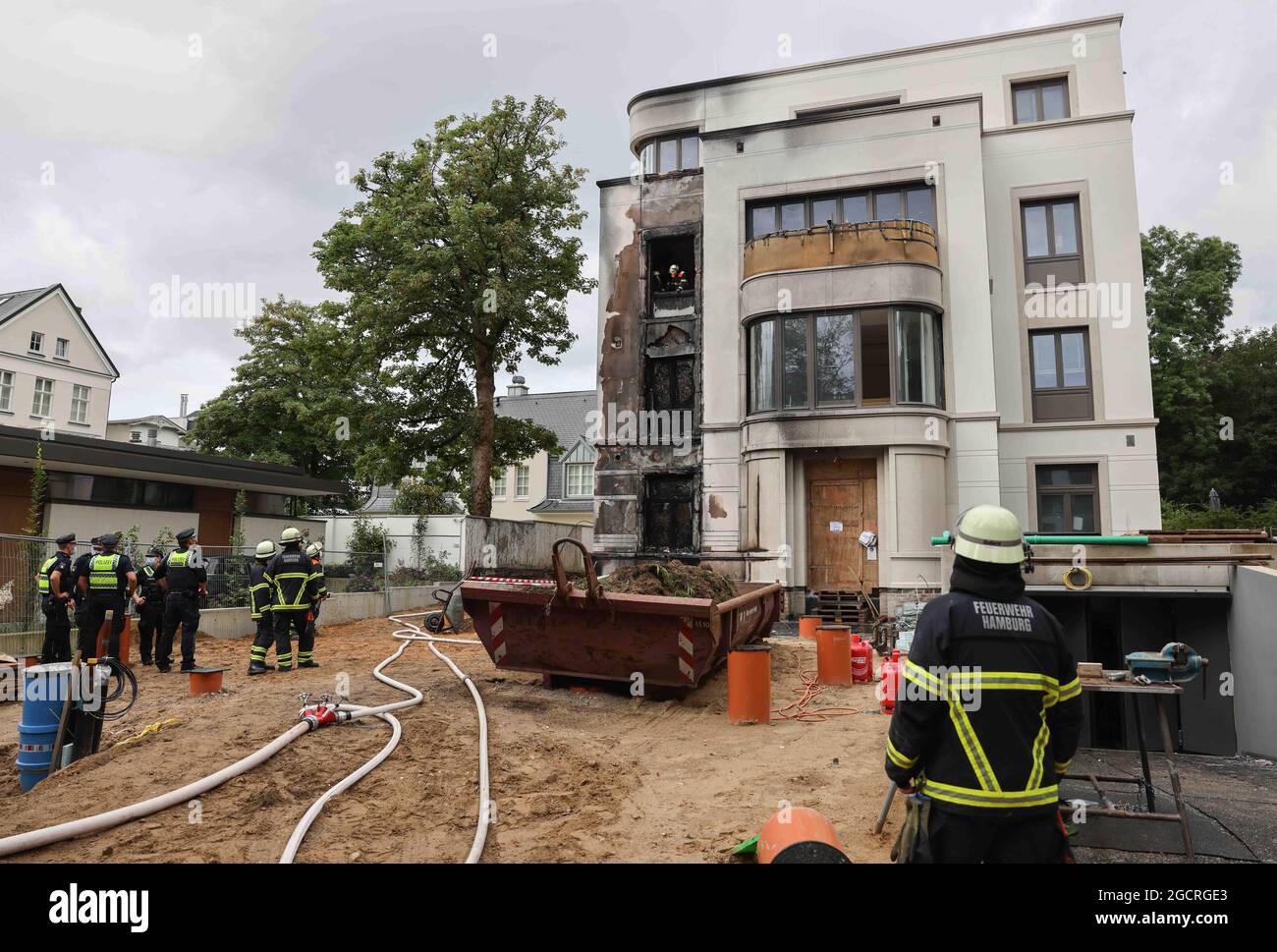 Hamburg, Deutschland. August 2021. Feuerwehrleute löschen einen Brand in Hamburg-Rotherbaum. Das Feuer mit starker Rauchentwicklung durch die Verbrennung von Baumaterialien in einem Haus hat am Dienstagmorgen nahe der Hamburger Alster für Aufsehen gesorgt. Quelle: Christian Charisius/dpa/Alamy Live News Stockfoto