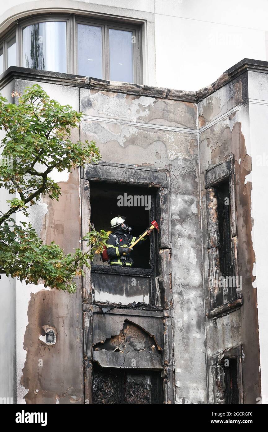 Hamburg, Deutschland. August 2021. Feuerwehrleute löschen einen Brand in Hamburg-Rotherbaum. Das Feuer mit starker Rauchentwicklung durch die Verbrennung von Baumaterialien in einem Haus hat am Dienstagmorgen nahe der Hamburger Alster für Aufsehen gesorgt. Quelle: Christian Charisius/dpa/Alamy Live News Stockfoto