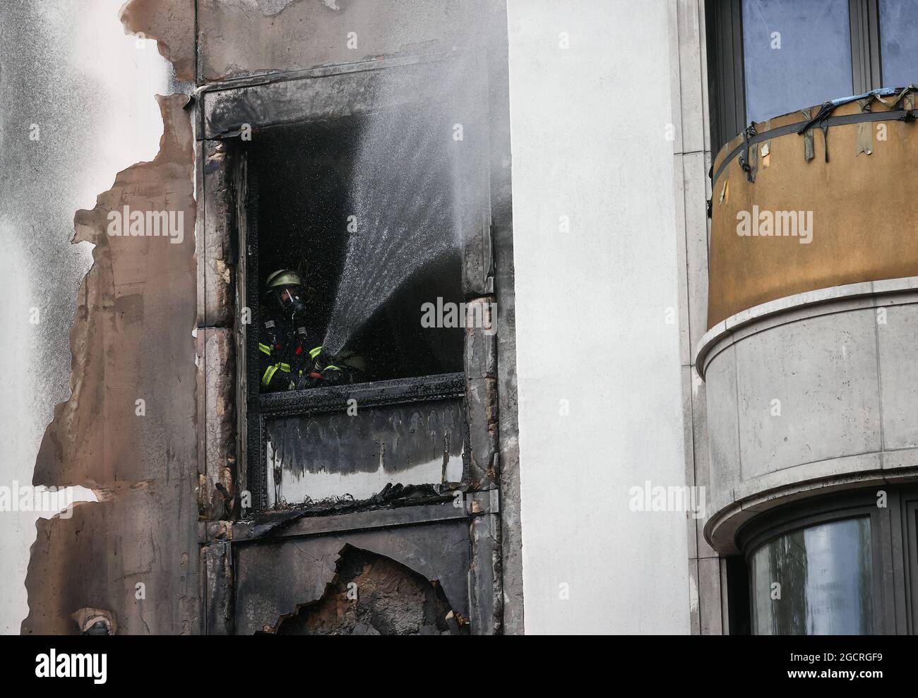 Hamburg, Deutschland. August 2021. Feuerwehrleute löschen einen Brand in Hamburg-Rotherbaum. Das Feuer mit starker Rauchentwicklung durch die Verbrennung von Baumaterialien in einem Haus hat am Dienstagmorgen nahe der Hamburger Alster für Aufsehen gesorgt. Quelle: Christian Charisius/dpa/Alamy Live News Stockfoto