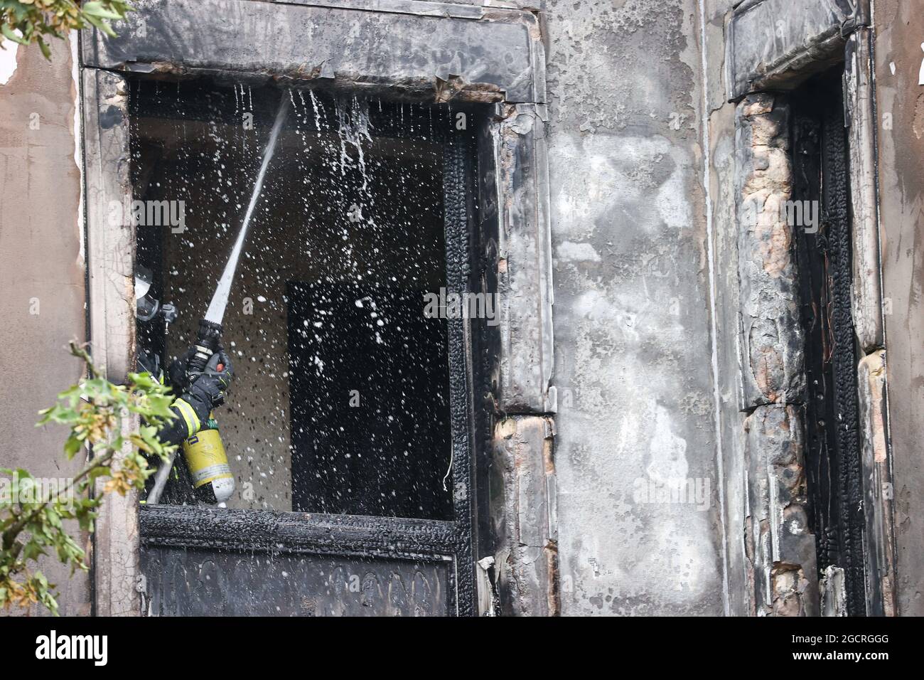 Hamburg, Deutschland. August 2021. Feuerwehrleute löschen einen Brand in Hamburg-Rotherbaum. Das Feuer mit starker Rauchentwicklung durch die Verbrennung von Baumaterialien in einem Haus hat am Dienstagmorgen nahe der Hamburger Alster für Aufsehen gesorgt. Quelle: Christian Charisius/dpa/Alamy Live News Stockfoto
