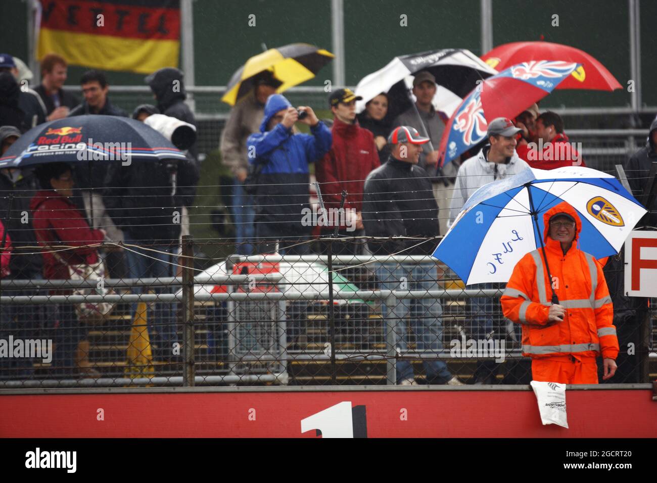 Fans und Marschalls trotzen dem Regen auf den Tribünen. Großer Preis von Großbritannien, Freitag, 6. Juli 2012. Silverstone, England. Stockfoto