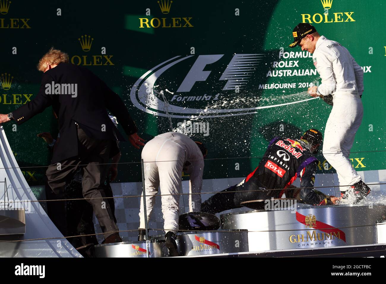 Kevin Magnussen (DEN) McLaren ist der einzige, der als Rennsieger Nico Rosberg (GER) Mercedes AMG F1 und Daniel Ricciardo (AUS) Red Bull Racing (Mitte) auf dem Podium steht, beide fallen, als der Champagner versprüht wird. Großer Preis von Australien, Sonntag, 16. März 2014. Albert Park, Melbourne, Australien. Stockfoto