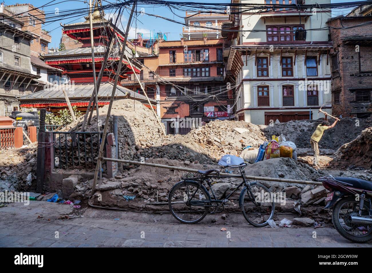 Ein Mann, der nach dem Erdbeben in Nepal im April 2015 in Kathmandu, Nepal, mit einer Spitzhacke Trümmer räumte Stockfoto