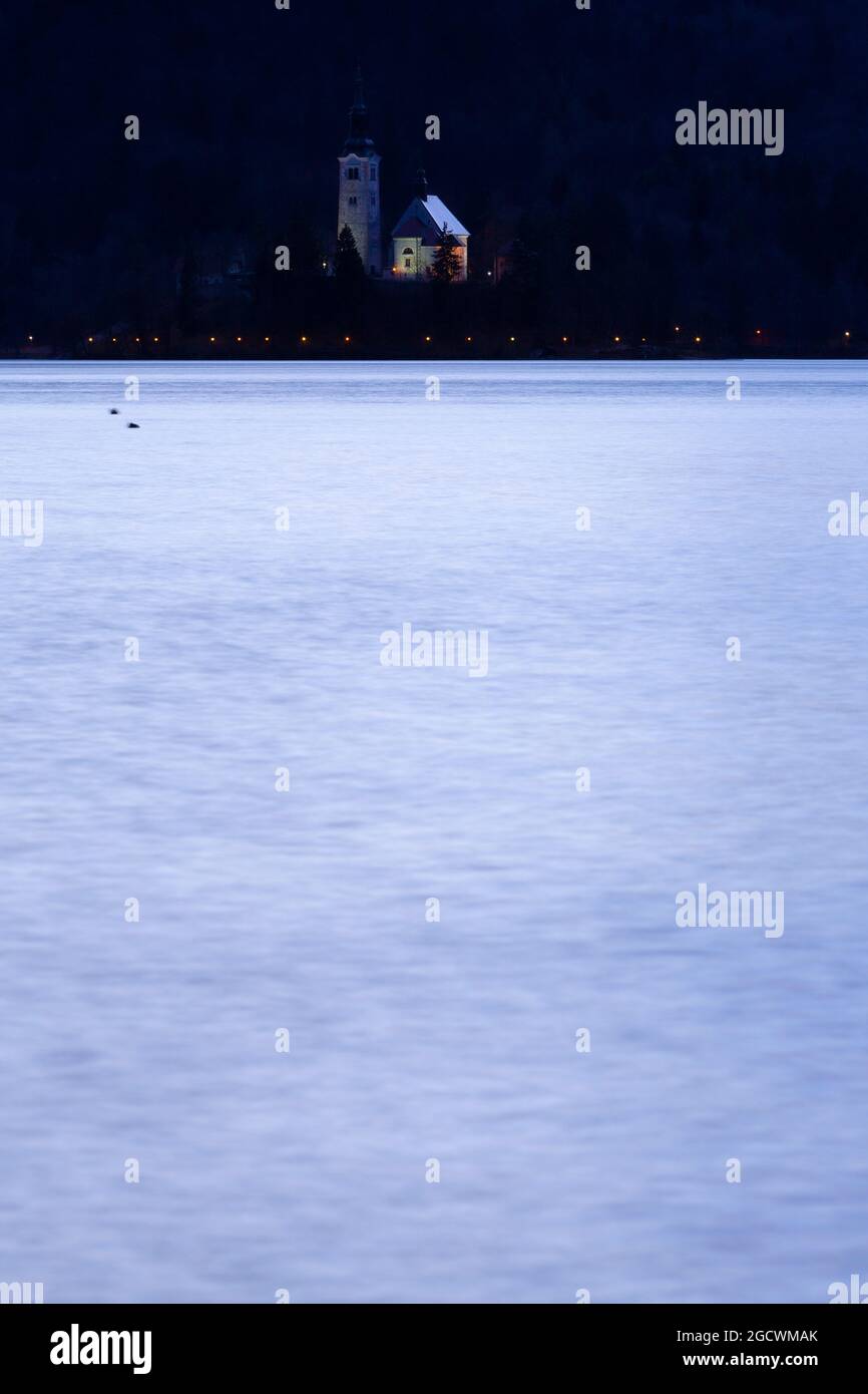 Bleder See (BLEJSKO JEZERO) in der Abenddämmerung mit der Wallfahrtskirche Mariä Himmelfahrt (CERKEV MARIJINEGA VNEBOVZETJA) Stockfoto