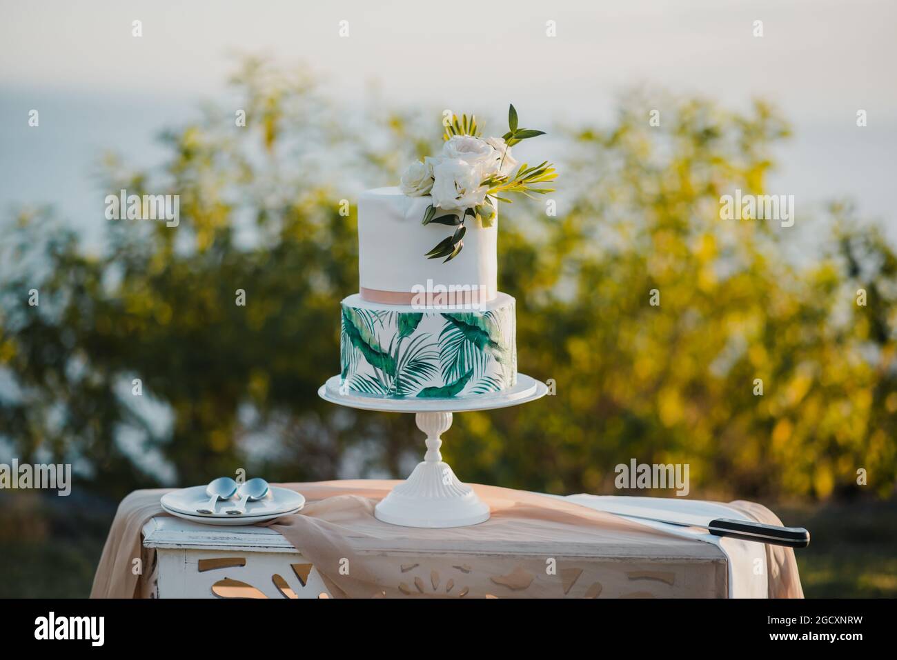 Tisch mit Hochzeitstorte im Grünen Stockfoto
