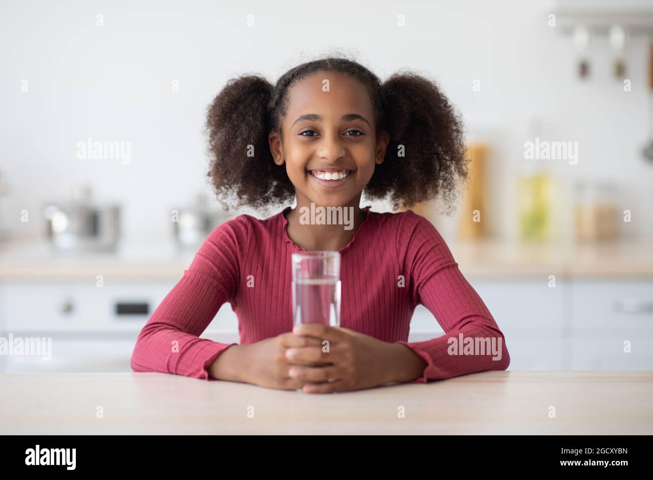 Fröhliche afroamerikanische Mädchen Teenager Trinkwasser Stockfoto