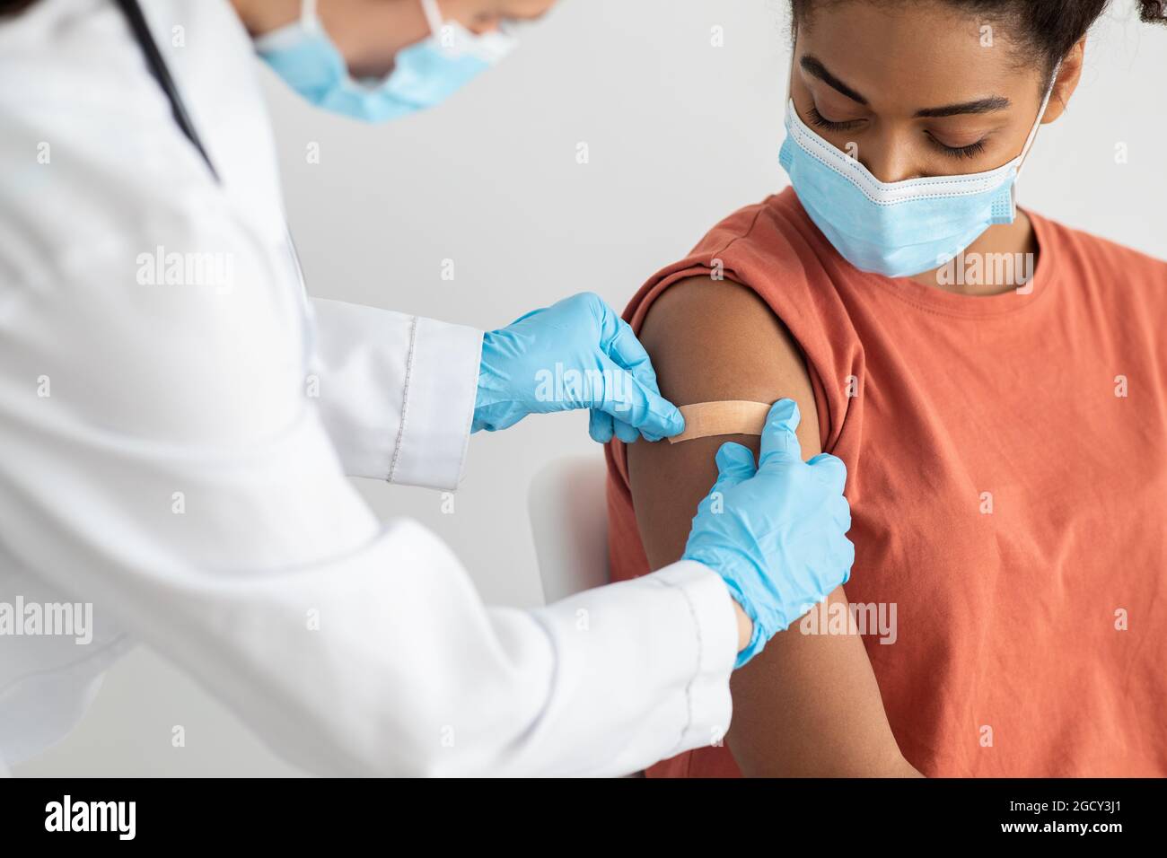 Krankenschwester, die medizinischen Pflaster auf den weiblichen Patientenarm legt Stockfoto