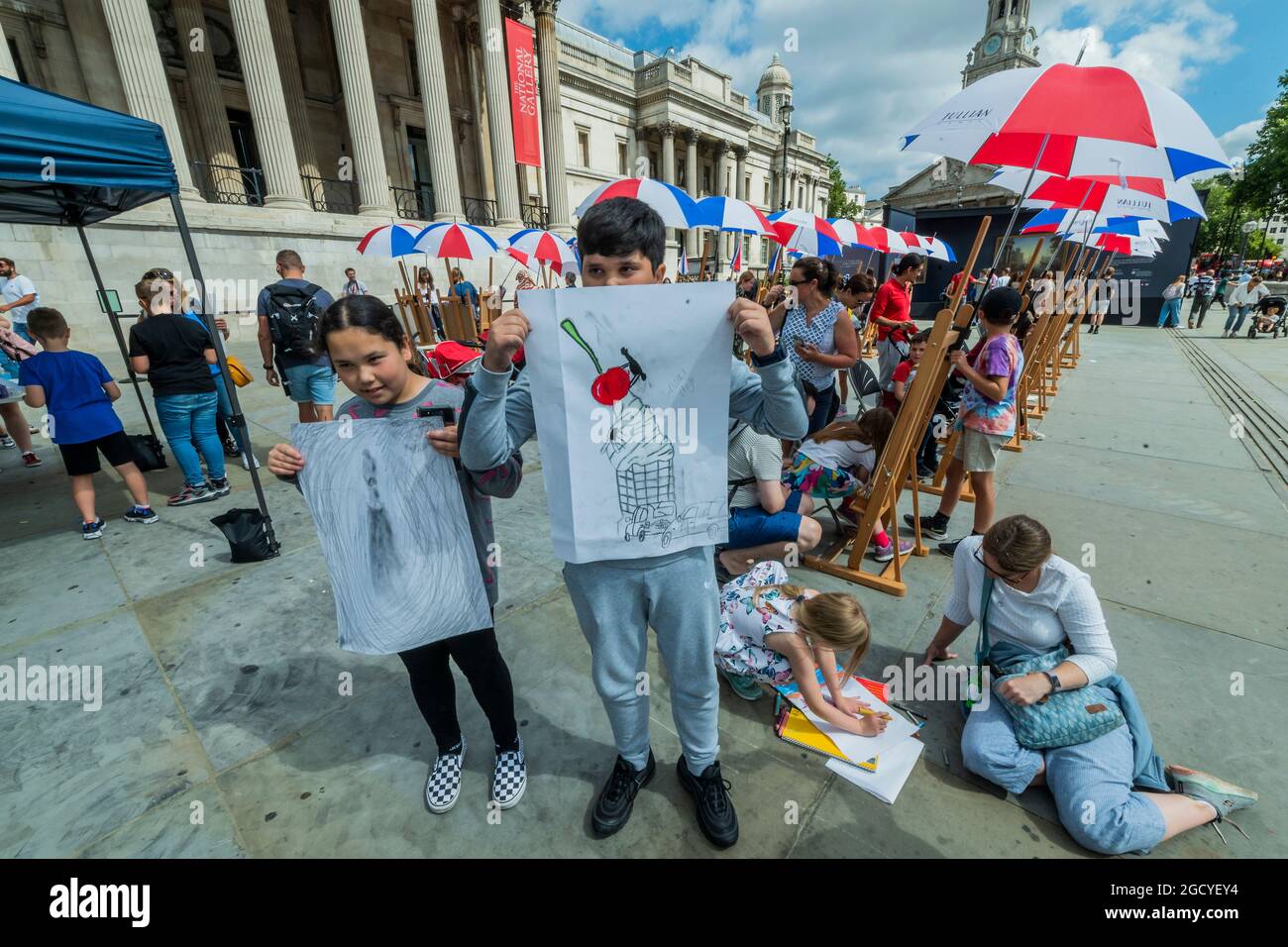 London, Großbritannien. August 2021. Ein paar Kinder zeigen ihre Werke - eine Pop-up-Galerie im Freien zeigt neben Sketch on the Square über 20 Reproduktionen beliebter Meisterwerke der National Gallery - und bringt Kunst im Rahmen des Inside Out Festivals, einem Monat kostenloser interaktiver Kunstveranstaltungen auf dem Trafalgar Square, in die freie Natur. Den ganzen August 2021 vor der Nationalgalerie, in Zusammenarbeit mit dem Stadtrat von Westminster. Kredit: Guy Bell/Alamy Live Nachrichten Stockfoto