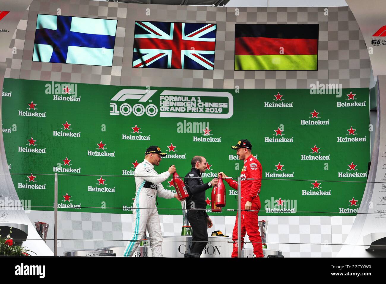 (L bis R): Valtteri Bottas (FIN) Mercedes AMG F1 feiert mit Marcus Dudley (GBR) Mercedes AMG F1 Performance Engineer und Sebastian Vettel (GER) Ferrari auf dem Podium. Großer Preis von China, Sonntag, 14. April 2019. Shanghai, China. Stockfoto