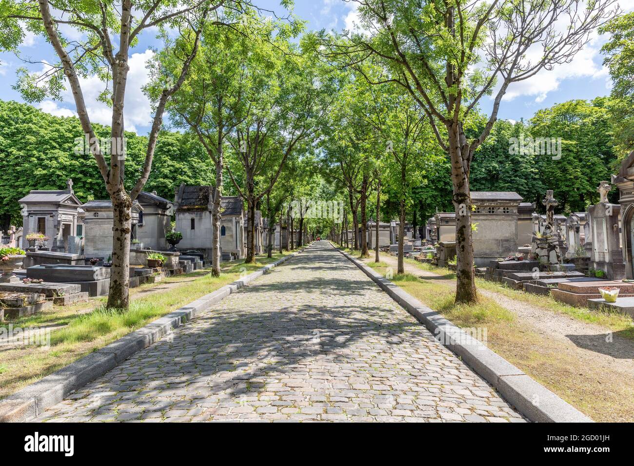 Schattige, von Bäumen gesäumte Gasse auf dem Friedhof Père Lachaise in Paris Stockfoto