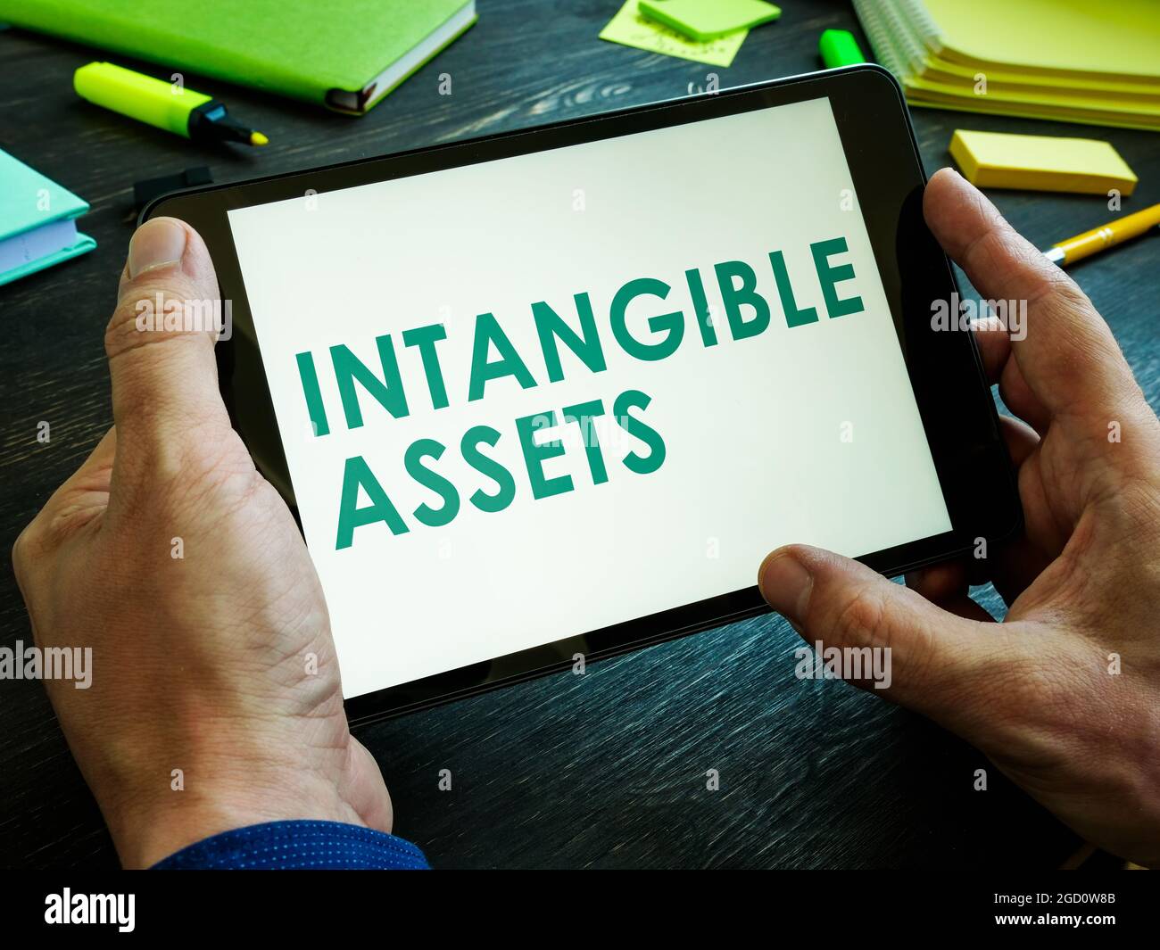 Man liest den Bericht über immaterielle Vermögenswerte auf dem Tablet. Stockfoto