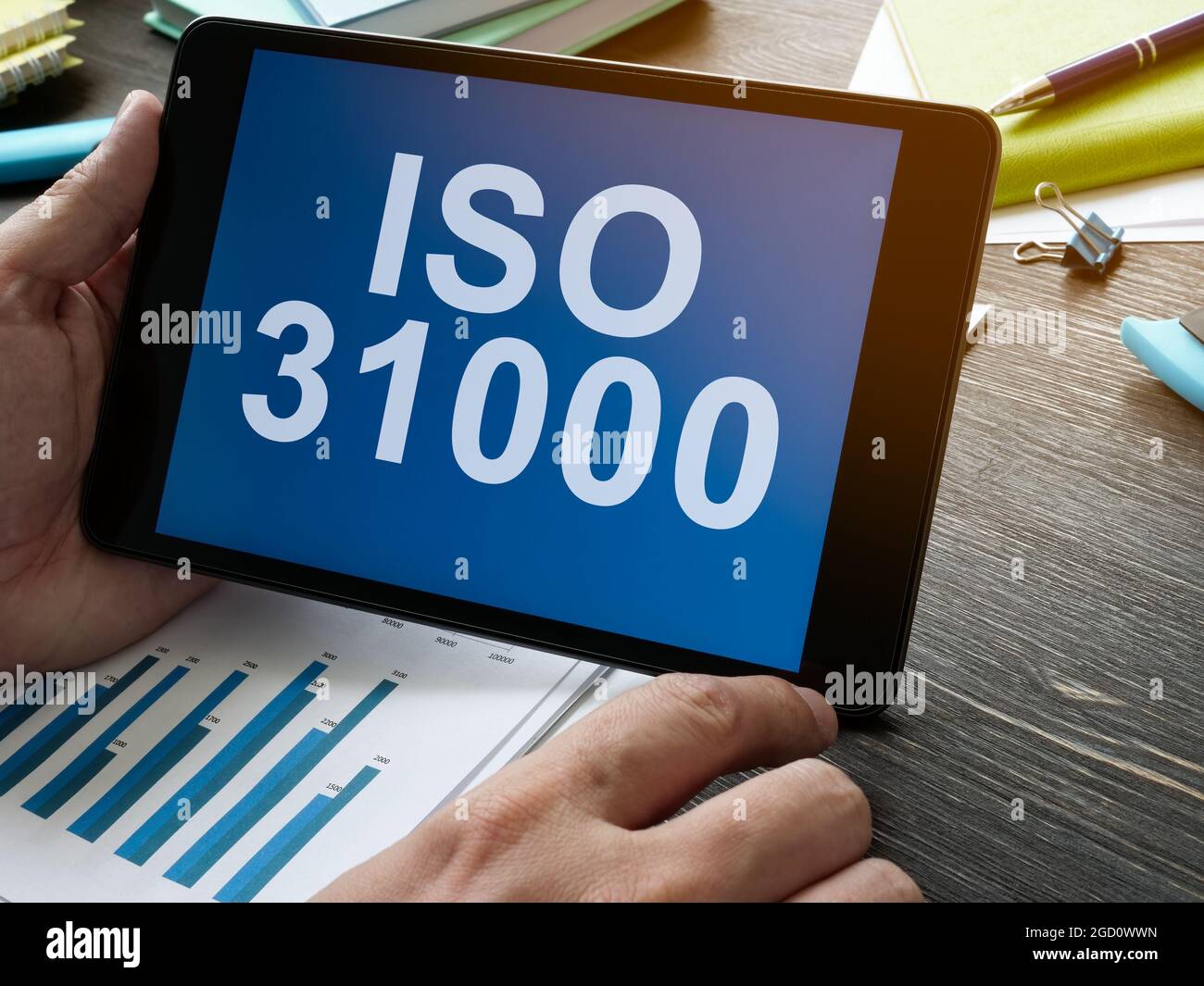 Die Hand hält das Tablett mit Daten über ISO 31000. Stockfoto
