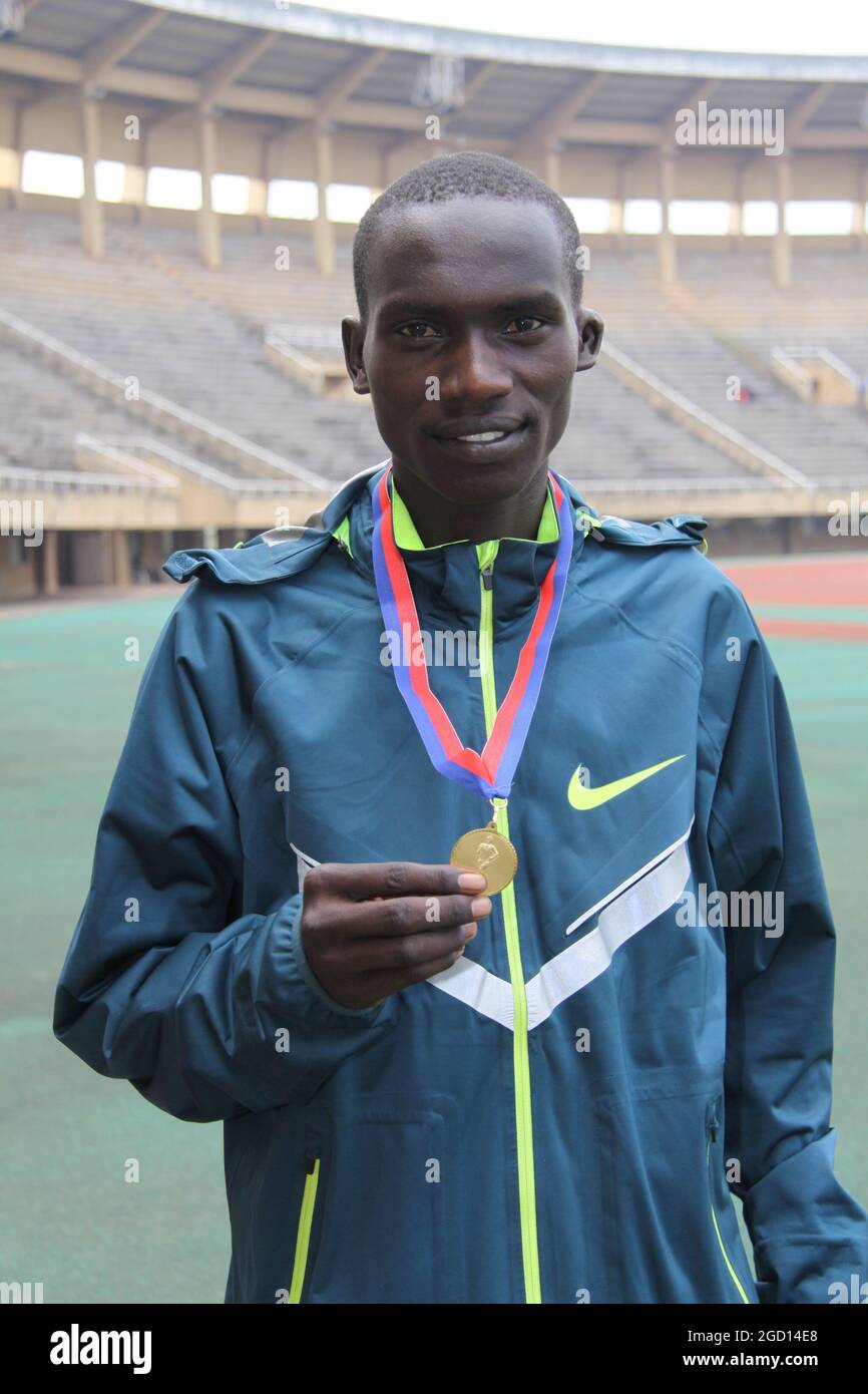 Ein junger Joshua Cheptegei (17 Jahre) mit seiner Goldmedaille, der bei den Uganda National Championships am 12. Juli 2014 die 5000-Meter-Rennen der Herren gewonnen hatte. Stockfoto