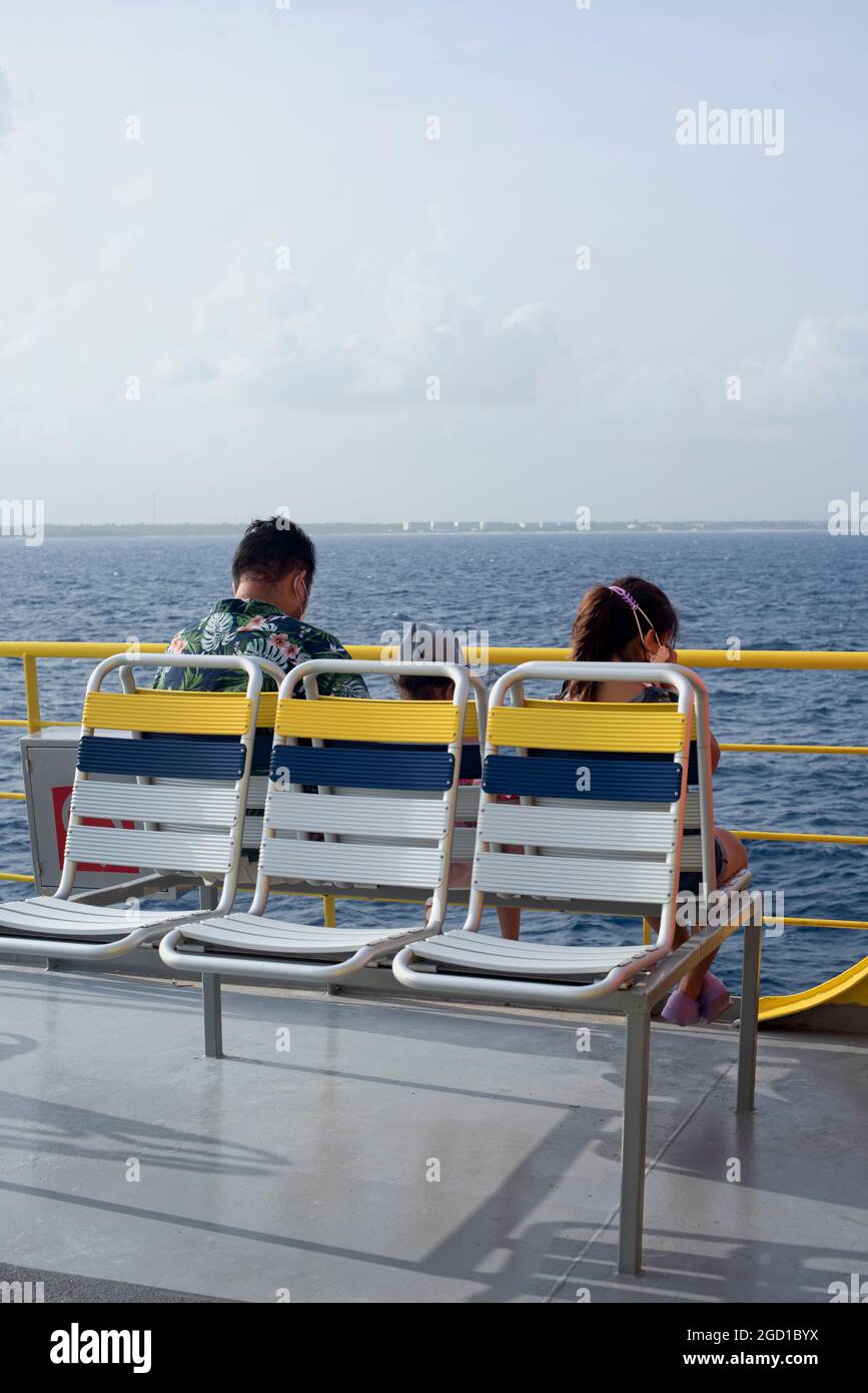 Passagiere, die in einer Fähre auf dem offenen Deck sitzen und im Kanal der tropischen Insel Cozumel in Mexiko segeln Stockfoto