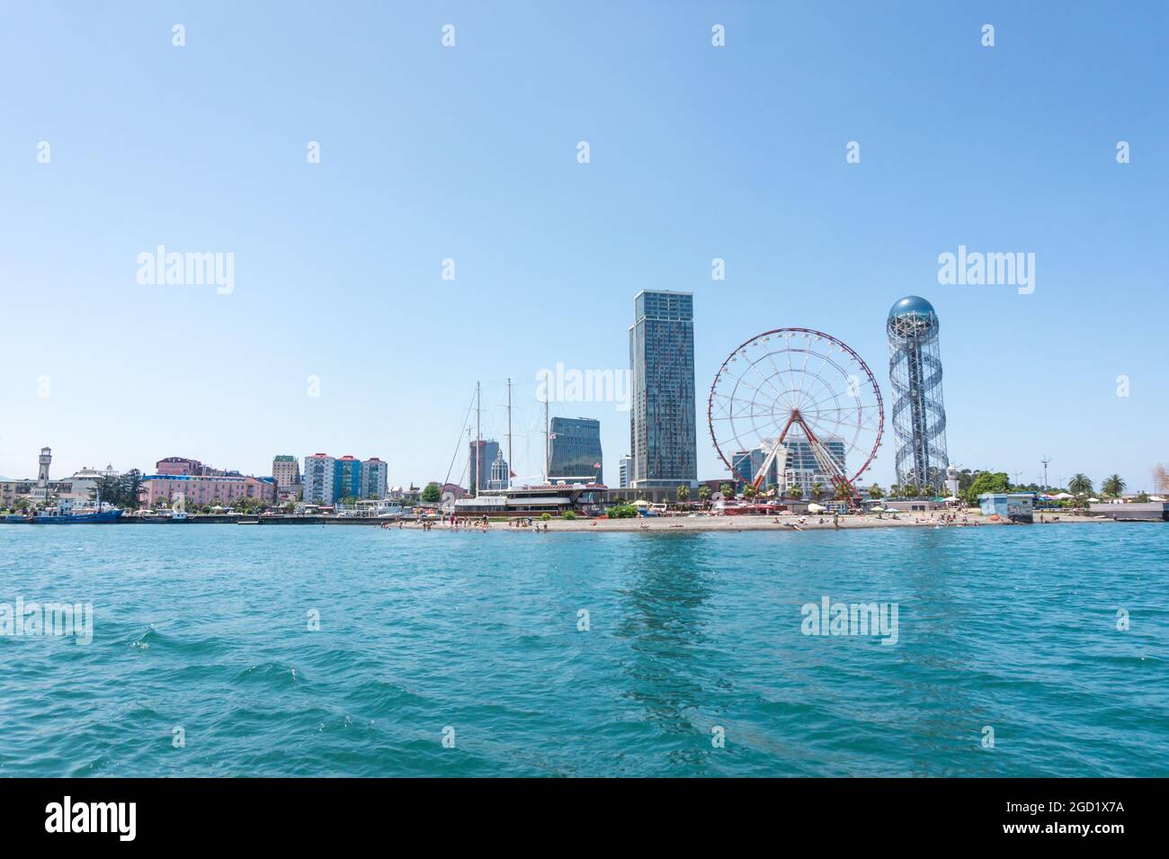 Batumi, Georgia - 2. Juli 2021: Batumi Coastline. Beliebte georgische Urlaubsstadt am Schwarzen Meer. Panoramablick auf das Riesenrad, den alphabetischen Turm, Wolkenkratzer und den Strand vom Meer aus. Stockfoto