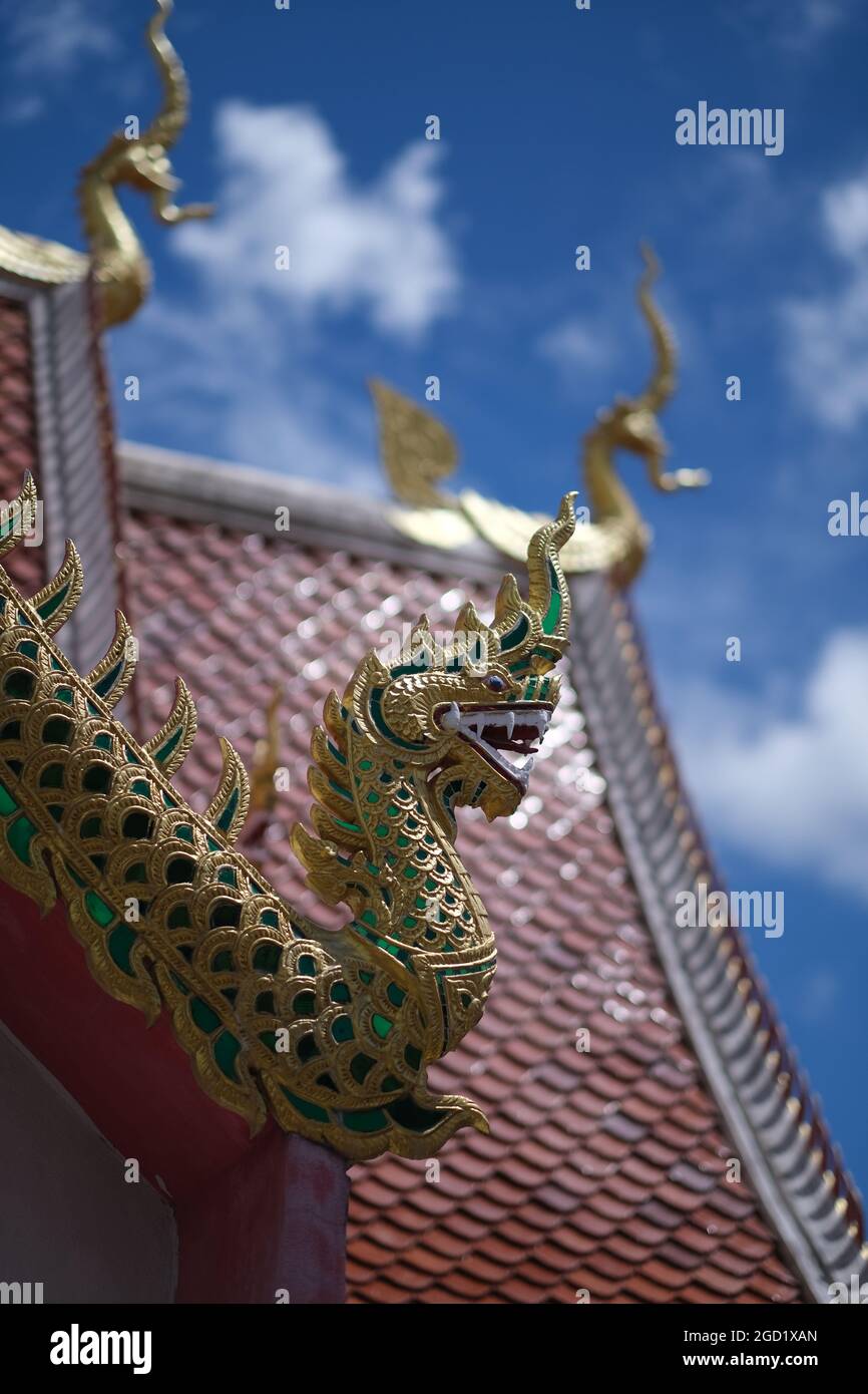Ein Drache auf dem Dachrücken des buddhistischen Tempels und ein klarer blauer Himmel dahinter Stockfoto
