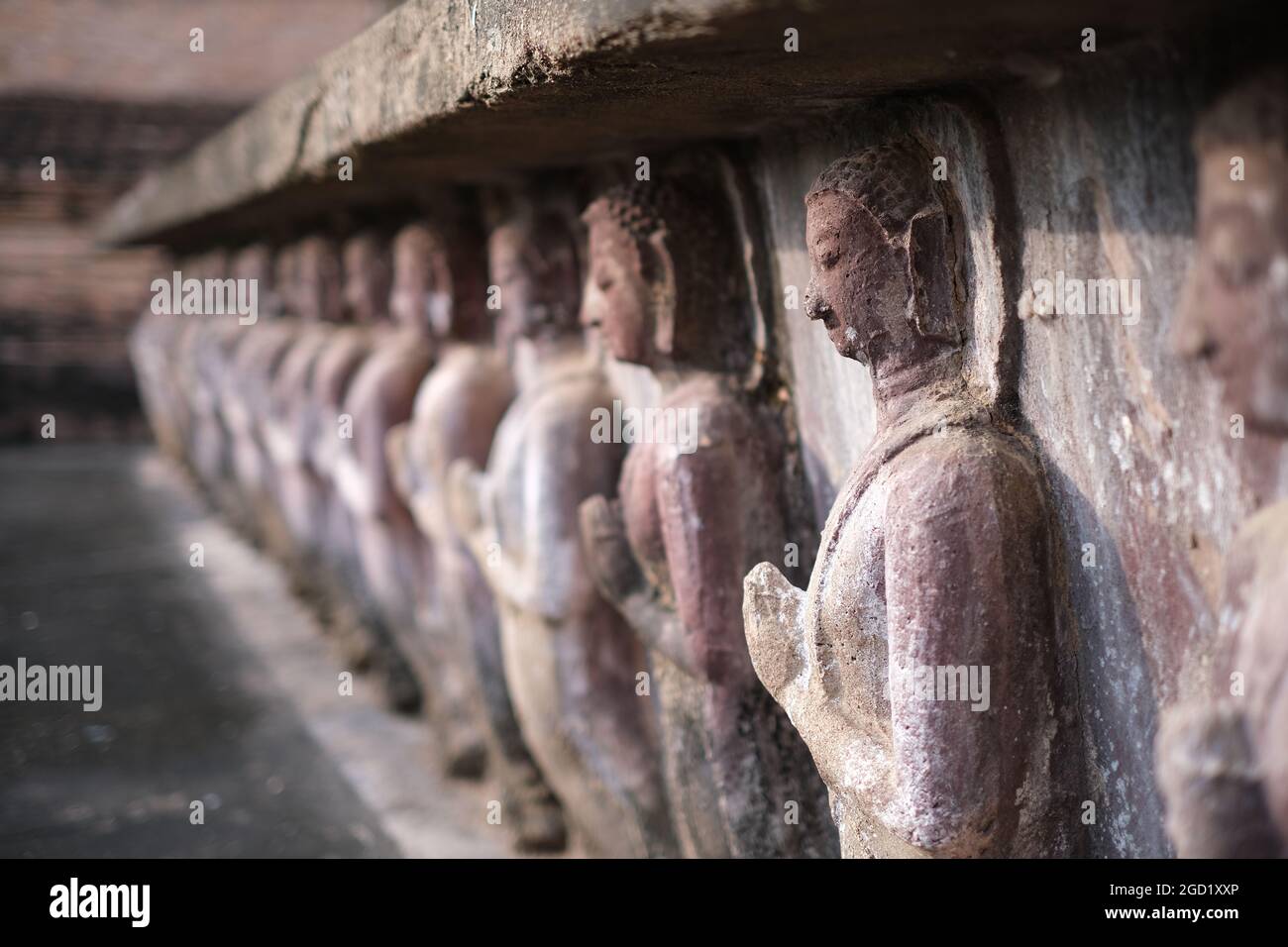 Eine Reihe von buddhas (oder einfach nur biddhistische Mönche), geschnitzt auf der Basis des alten Palastes Stockfoto