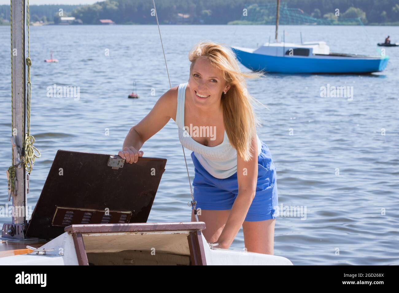 Fröhliche junge Frau auf dem Hintergrund von Yachten Stockfoto