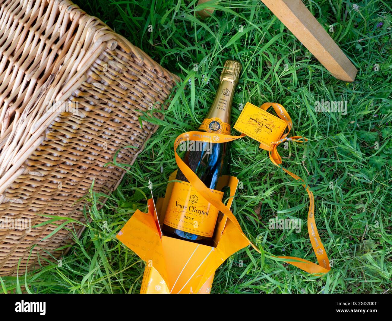 Veuve Clicquot Luxus-Champagner-Flasche & Präsentationsbox mit Band, Picknickkorb im Freien bei grünen Outdoor-Gelegenheiten Stockfoto