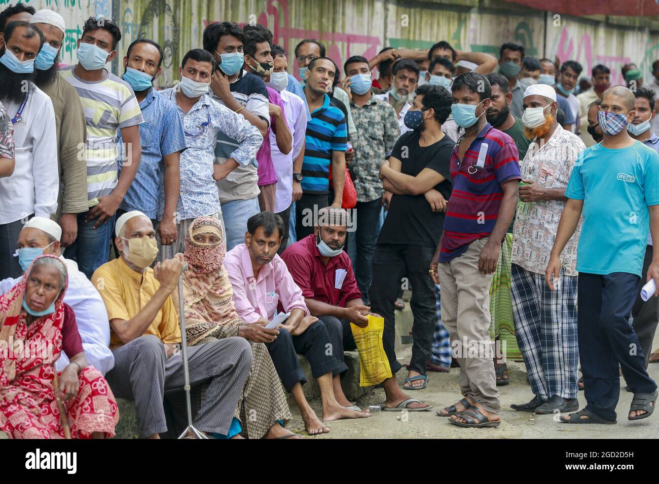 Dhaka, Bangladesch, 10. August 2021. Die Menschen warten in einer Schlange, um den Covid-19-Impfstoff in einem Impfzentrum zu erhalten, während die Regierung ihre Impfkampagne an die Basis in Dhaka, Bangladesch, am 10. August 2021, unternimmt. Nach Angaben der Regierung stieg die Zahl der entdeckten neuartigen Coronavirus-Fälle in Bangladesch am Dienstag auf 13,76,322 an, da 11,164 weitere Fälle gemeldet wurden, nachdem in den letzten 24 Stunden 47,424 Proben, einschließlich Schnellantigen-Tests, getestet wurden. Während dieses Zeitrekords starben 264 weitere Covid-19-Patienten, was die Gesamtzahl der Todesfälle im Land auf 23,161 erhöht. Foto von Suvra Kanti das/ABACAPRE Stockfoto