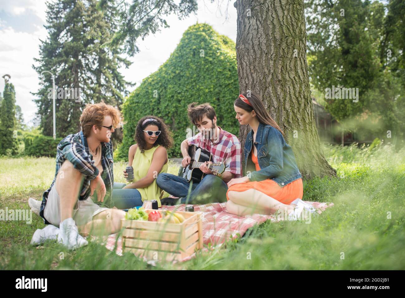 Junge optimistische Menschen, die sich im Park ausruhen Stockfoto