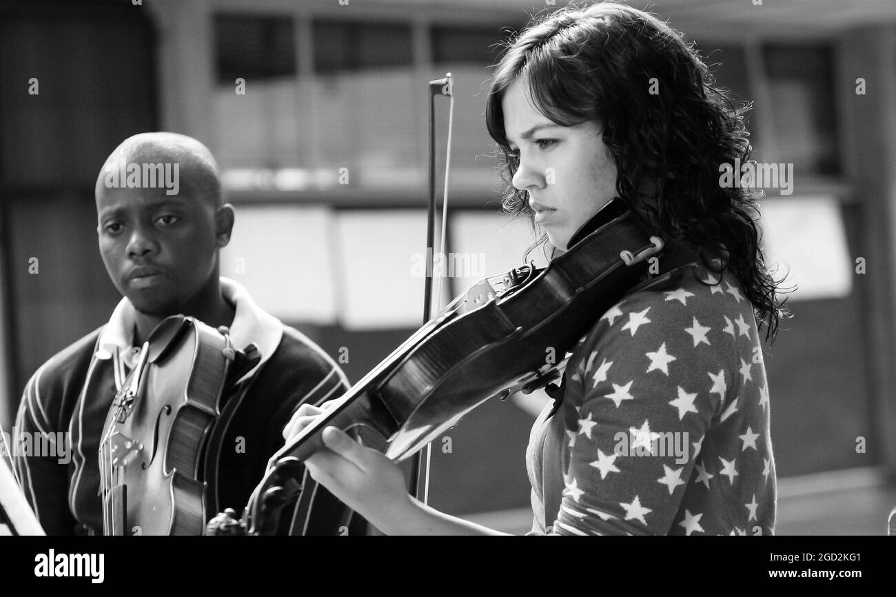 JOHANNESBURG, SÜDAFRIKA - 05. Jan 2021: Eine Graustufe von Studenten, die in einem Musikschulorchester in Johannesburg, Südafrika, Violine spielen Stockfoto