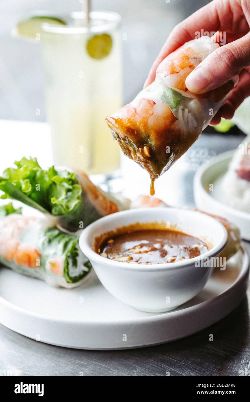 vietnamesische frische Salatrolle, die in eine Erdnusssauce getaucht wird Stockfoto