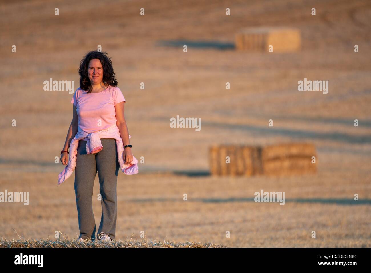 Latina mittleren Alters und eine brünette Frau in rosa und grauer Sportkleidung, die in ländlicher Umgebung auf dem Land unterwegs ist. Selektiver Fokus. Der Blick auf kam Stockfoto