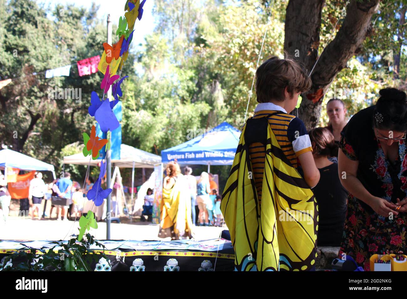PASADENA, Kalifornien - EIN Monarch-Festival mit einem Dia de los Muertos-Twist! Beim Dia de los Muertos Monarch Butterfly Festival, das am 28. Oktober 2017 in Pasadena stattfand, hängen Kinder und Erwachsene Papiermonarchen an einem Baum, um vergangene Geliebte und überwinterende Monarchen zu repräsentieren. Stockfoto