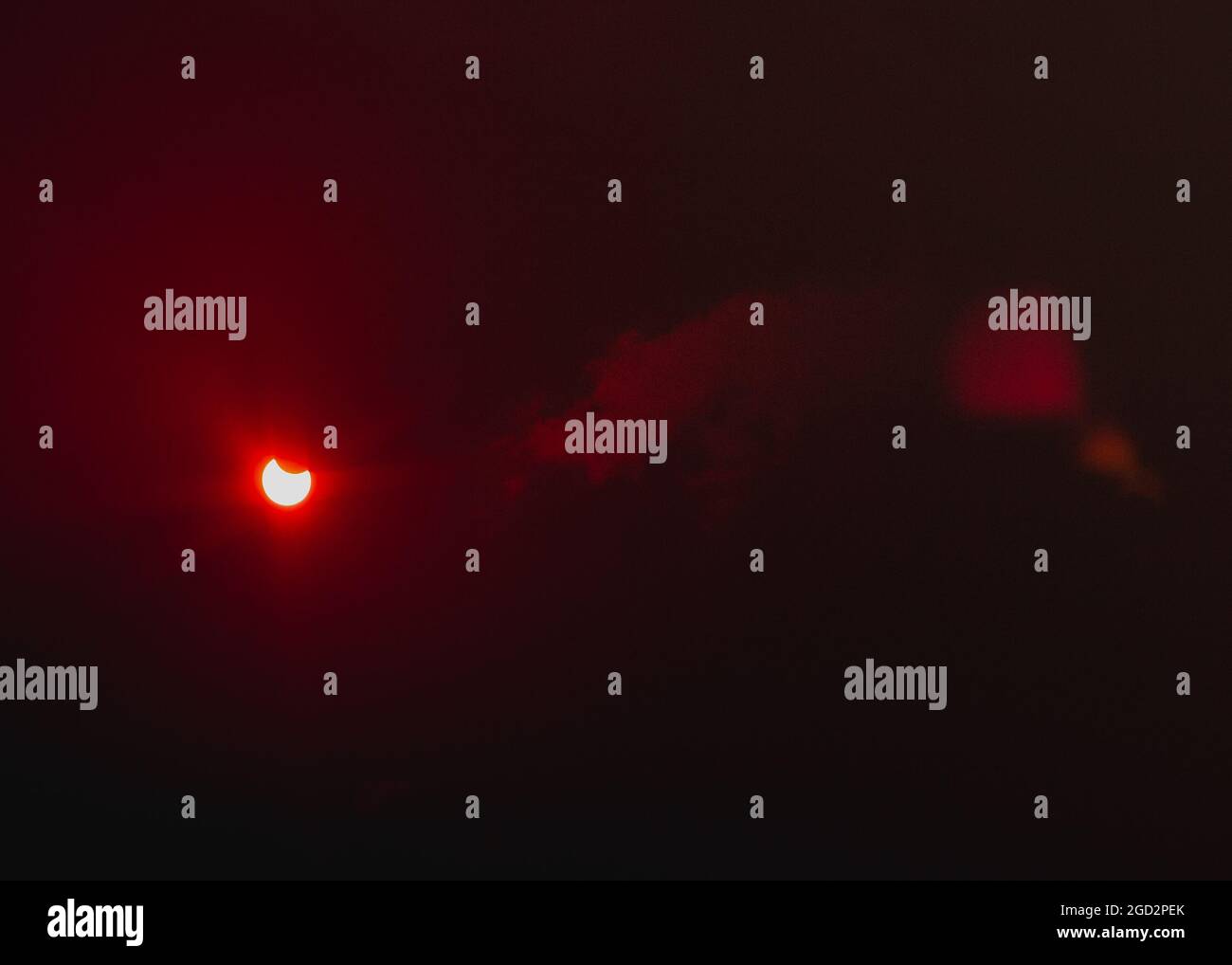 Eine partielle Sonnenfinsternis durch Floppyband und dünne Wolken. Stockfoto