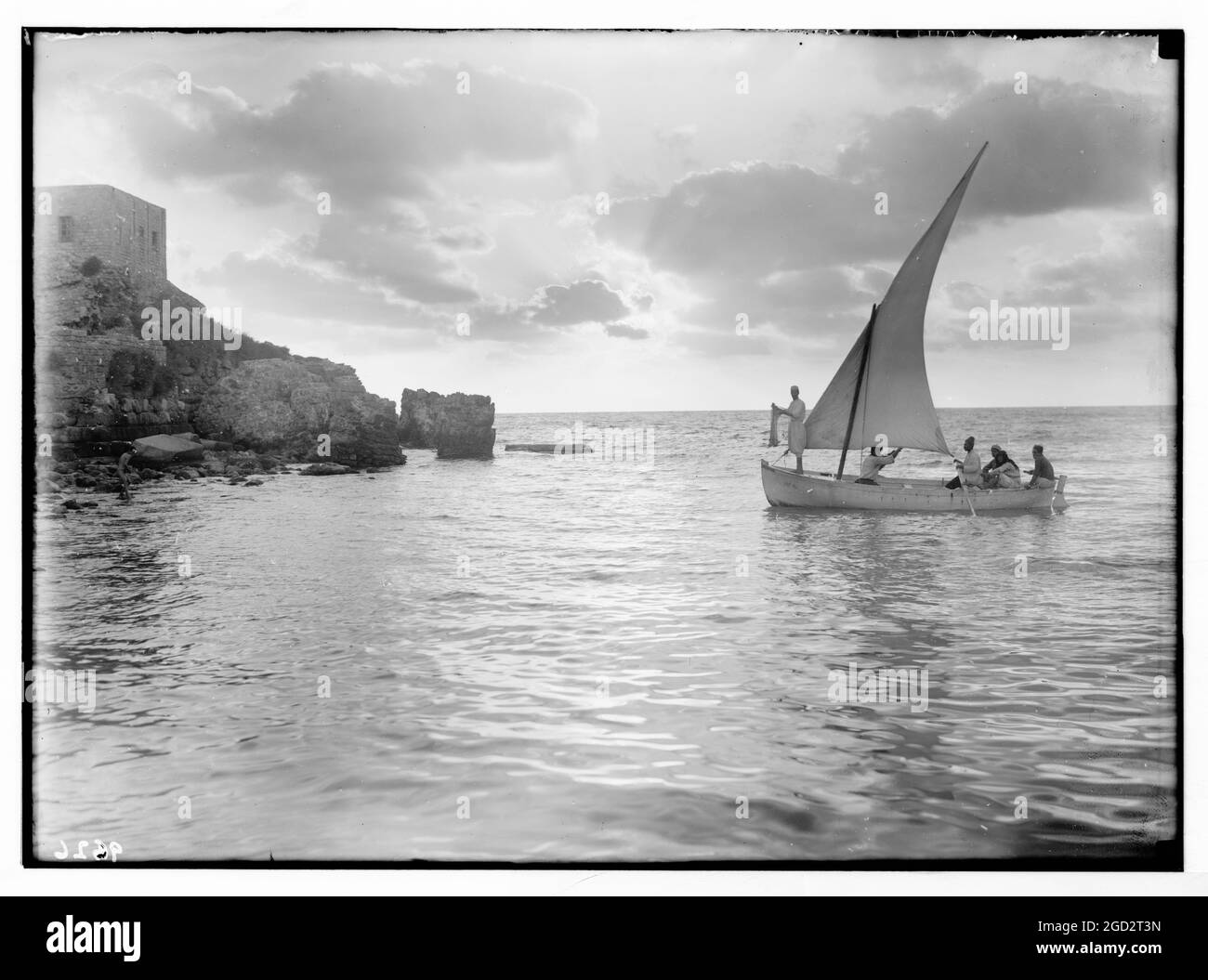 Caesarea, Israel in den 1930er Jahren, (Kaisarieh). Sonnenuntergangsszene mit Männern in einem Fischerboot (Burg links, silhouettiert) ca. 1938 Stockfoto