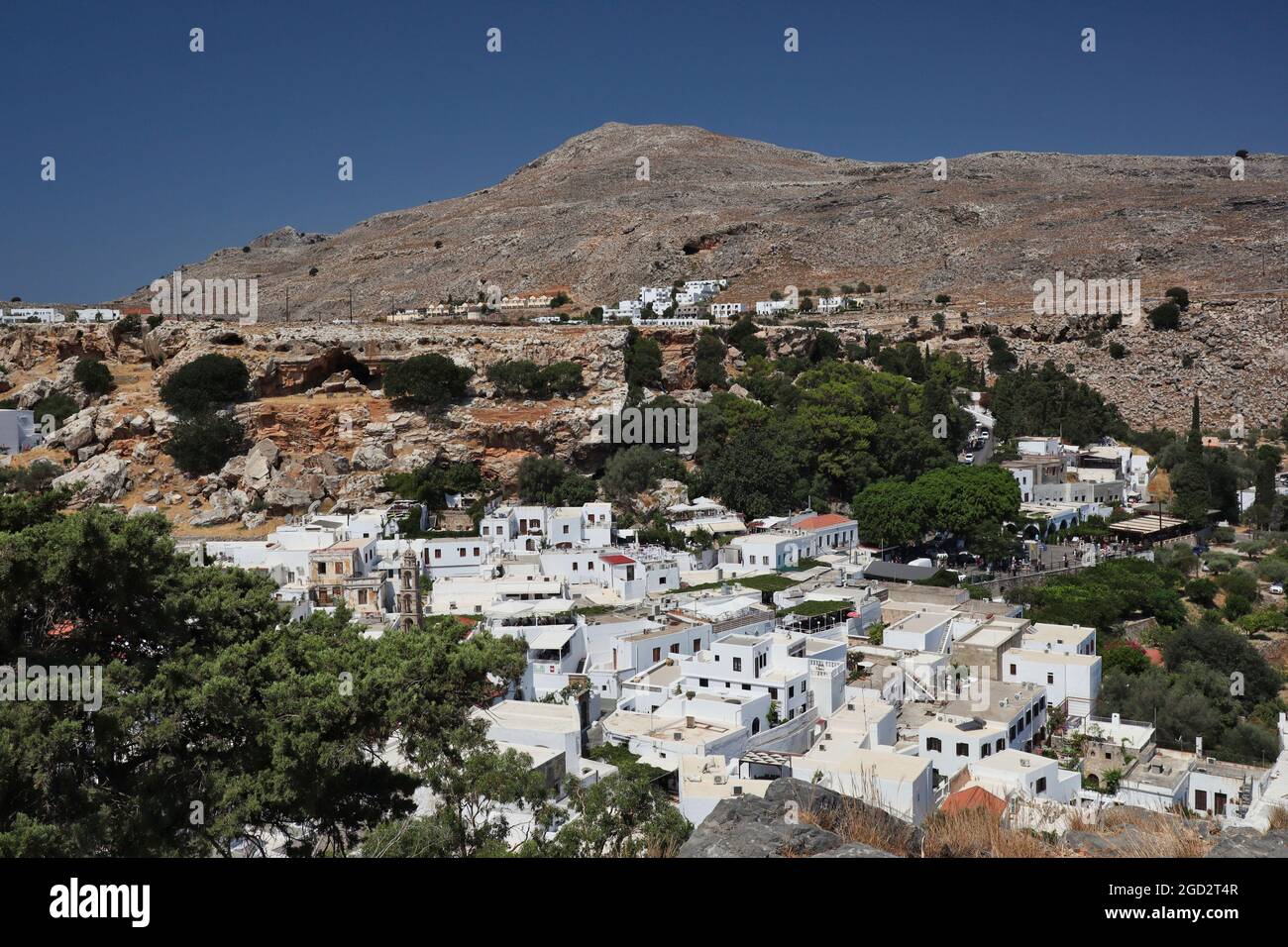 Lindos Dorf mit Weißen Häusern und Hügel während eines schönen Tages auf Rhodos. Touristisches griechisches Dorf mit blauem Himmel in Griechenland. Stockfoto