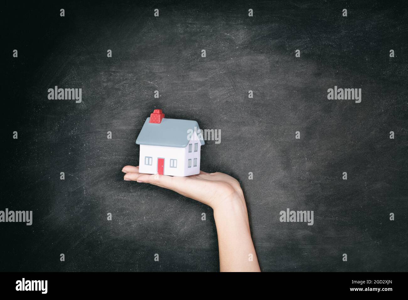 Real Estate Tafel Hintergrund - Neue Haus Eigentum Frau zeigt Miniatur-Haus Spielzeug für Hausbesitzer Konzept Plakatwand. Stockfoto