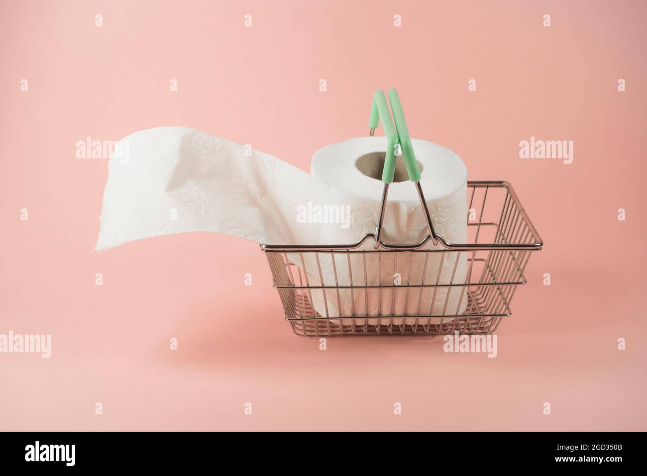 Toilettenpapier im Warenkorb aus Stahl. Auf trendigem Pastellhintergrund. Kauf von hygienischen und hygienischen Materialien. Pandemie-Idee. Minimaler Konsumerismus Stockfoto