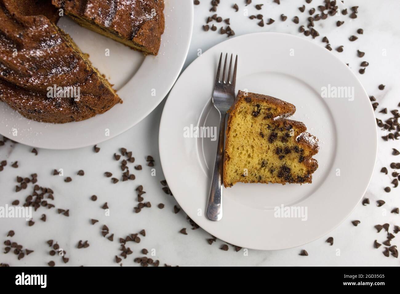 Ein verzierter und dekorativer hausgemachter und frischer Schokoladensplitterkuchen mit einem auf einem Servierteller ausgeschnittenen Clice Stockfoto