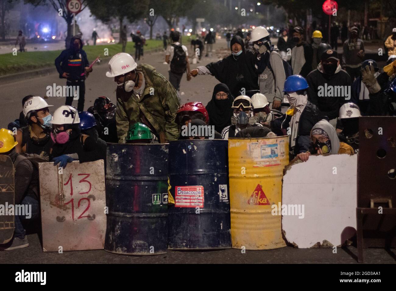 Bogota, Kolumbien, 09/08/2021, Demonstranten, die Schilde aus Holz und Metall verwendeten, um Wasser- und Tränengasbehälter zu bedecken, die von einem bewaffneten Lastwagen der kolumbianischen Bereitschaftspolizei während der Anti-Regierung geschossen wurden, was zu Zusammenstößen zwischen Demonstranten und der kolumbianischen Bereitschaftspolizei (ESMAD) inmitten der Räumung von Demonstranten führte, die während der letzten 3 in den Tibabuyes lagerten Monatelange regierungsfeindliche Proteste im Norden Bogotas, Kolumbien Stockfoto