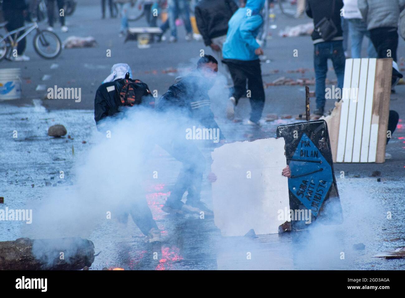 Bogota, Kolumbien, 09/08/2021, Demonstranten, die Holztüren aus Wasser- und Tränengaskanistern benutzten, die von einem gepanzerten Lastwagen der kolumbianischen Bereitschaftspolizei während der Anti-Regierung-Proteste angeschossen wurden, was in Zusammenstößen zwischen Demonstranten und der kolumbianischen Bereitschaftspolizei (ESMAD) endete, während die Demonstranten, die während der Anti-Regierungsproteste der letzten 3 Monate in den Tibabuyes lagerten, vertrieben wurden Im Norden Bogotas, Kolumbien Stockfoto