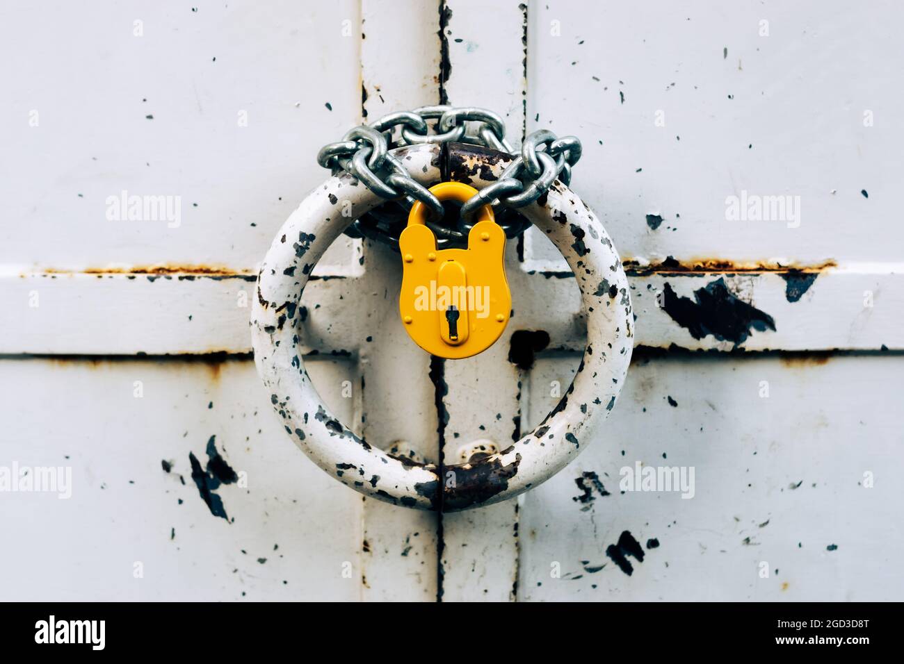 Altes, verschlossenes Vorhängeschloss hängt an der Kette. Schlechtes Sicherheitskonzept. Veraltete Sicherheitstechnologie Stockfoto