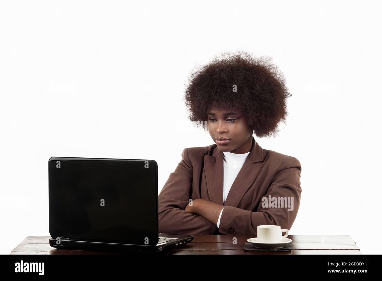 Junge, schwarze, lateinamerikanische Geschäftsführerin aus Latina, mit afro-Haaren, mit wütender Geste, die auf ihren Laptop schaut, auf weißem Hintergrund Stockfoto