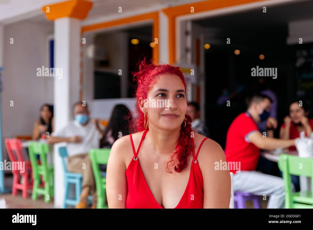 Porträt einer Latina-Frau mit roten Haaren, die in einem Café in einer kolumbianischen Stadt sitzt Stockfoto