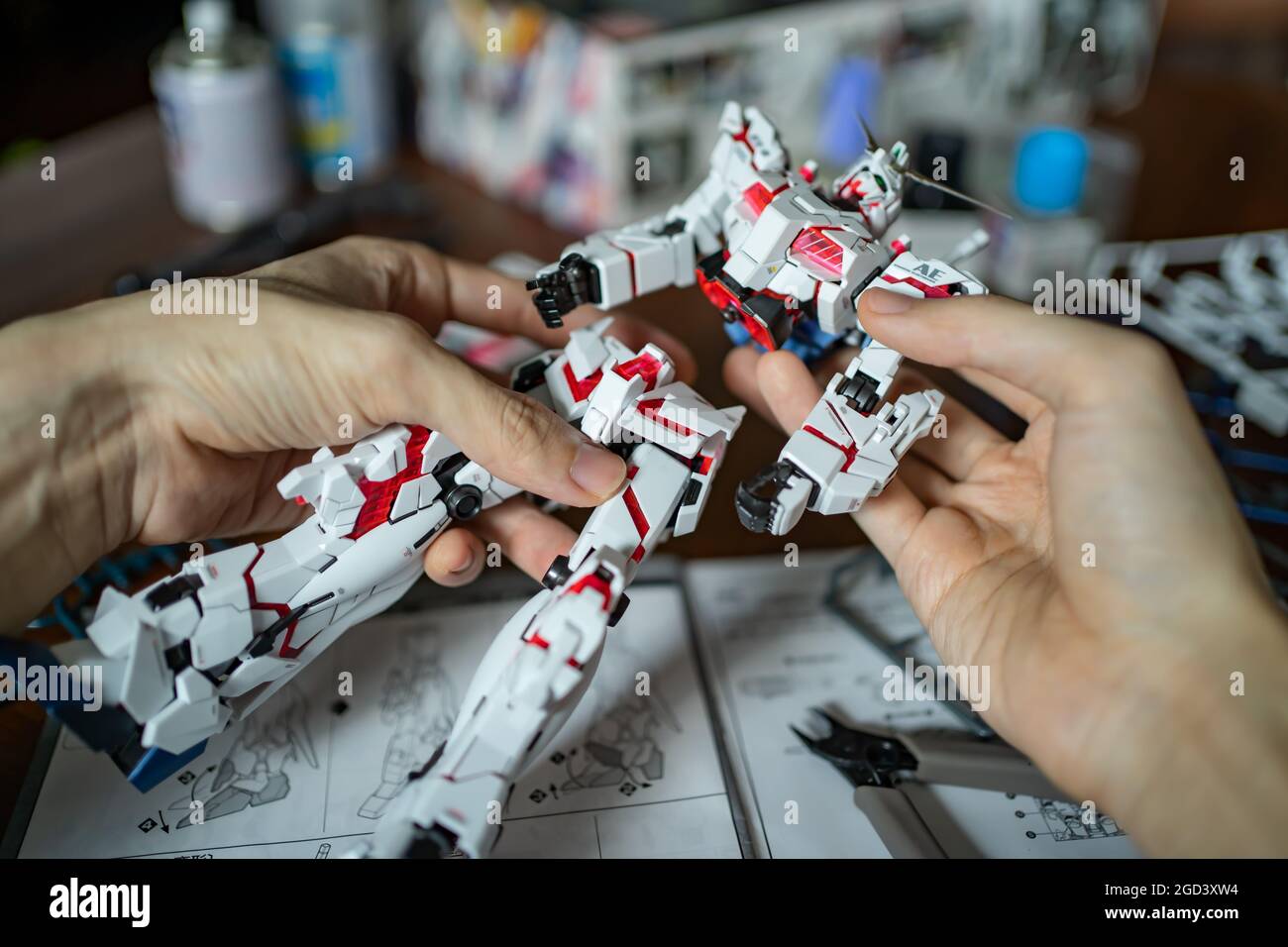 Bangkok, Thailand - 10. August 2021 : EIN Mann, der das Unicorn Gundam Plastikmodellbausatz zusammenstellt. Stockfoto