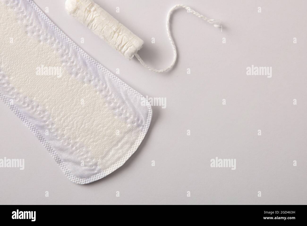 Hintergrund mit weiblichen Protektoren für den Menstruationszyklus. Pantiliner und Tampon auf weißem Hintergrund. Draufsicht. Horizontale Zusammensetzung. Stockfoto