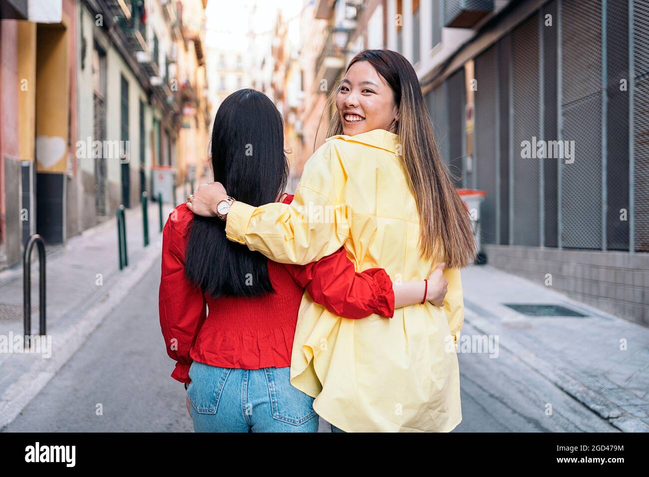 Hübsche asiatische Frau, die sich in den Straßen Madrids amüsieren und ihre Freundin umarmen kann. Stockfoto