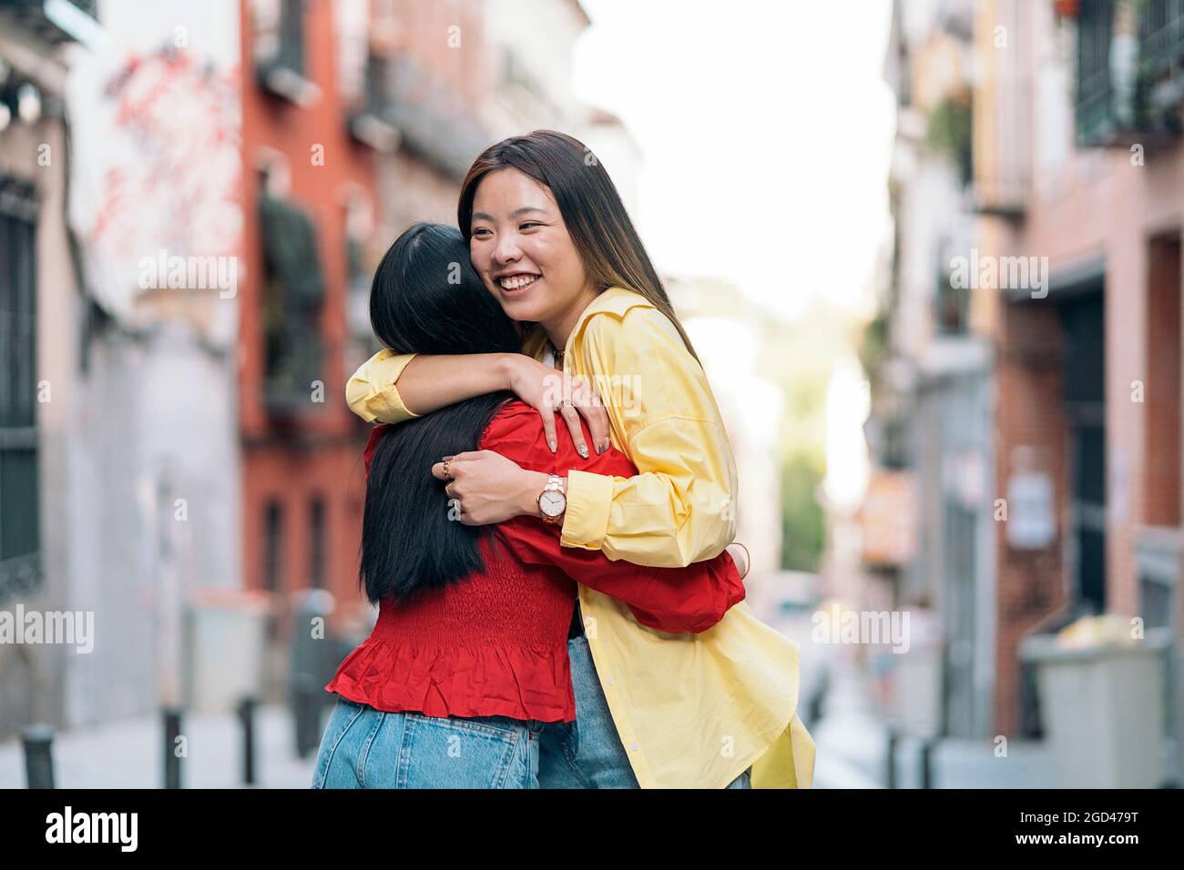 Glückliche asiatische Frau umarmt ihren Freund auf der Straße und Spaß haben. Stockfoto