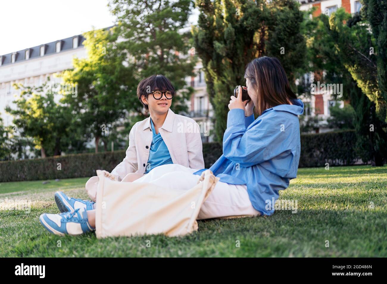 Unbekannte Frau, die im Park Fotos mit ihrem asiatischen Freund macht. Stockfoto