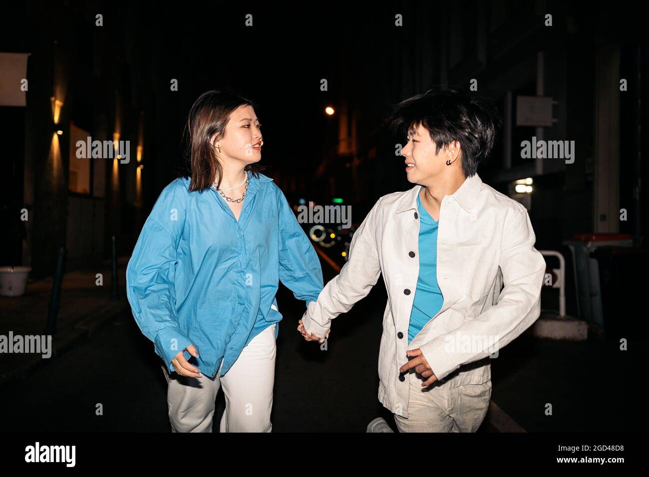 Cooles junges asiatisches Paar, das nachts in der Stadt Madrid spazierengeht und Spaß hat. Stockfoto