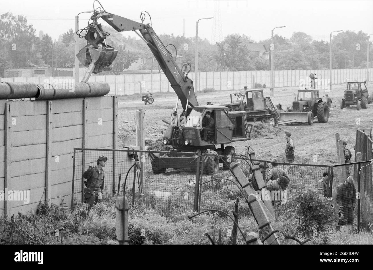 26. Mai 1986, Berlin: DDR-Grenztruppen reißen alte Grenzmauern und Zäune im Bezirk Neukölln nieder und ersetzen sie durch moderne, höhere Betonabschnitte. Am 13. August 2021 jährt sich der Bau der Berliner Mauer zum 60. Mal. Foto: Wolfgang Kumm/dpa Stockfoto