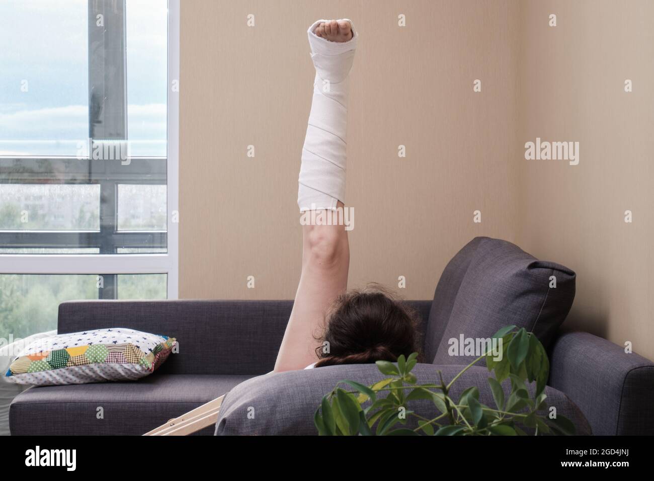 Eine Frau mit einem Cast auf ihrem Bein macht körperliche Übungen. Rehabilitation nach Verletzungen. Stockfoto