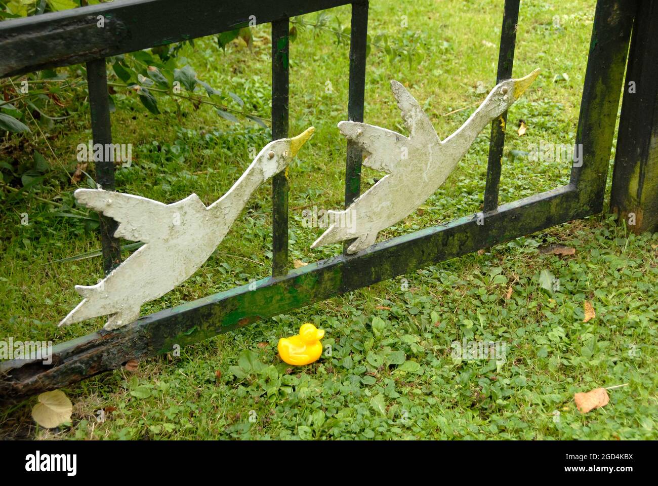 Kleine gelbe Plastikente auf dem Boden neben dem Tor, verziert mit zwei fliegenden Enten, Ludham, Norfolk, England Stockfoto