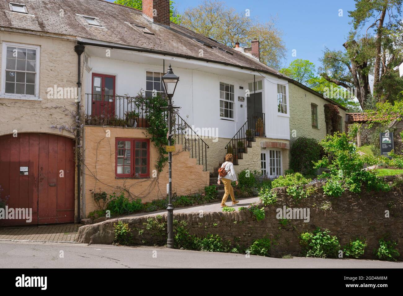 Devon, Blick im Sommer auf eine Frau mit Rucksack, die in der Castle Street in der historischen Stadt Totnes, South Hams, Devon, England, Großbritannien, spazieren geht Stockfoto